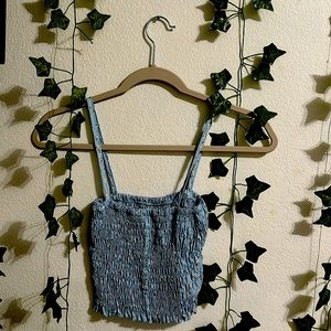 This is a string crop top. It has a design of tiny white flowers. Color is blue.